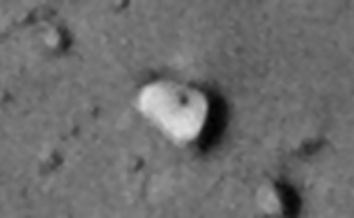 Rectangular megalith with rounded corners and a small feature or hole in the center