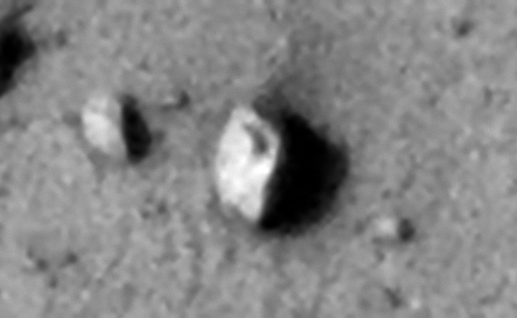 Rectangular megalith or metallic object with rounded corners and a small feature or hole in the center, note the straight edges and right-angles