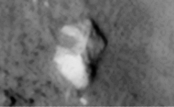 Partially buried, heavily eroded megalithic block