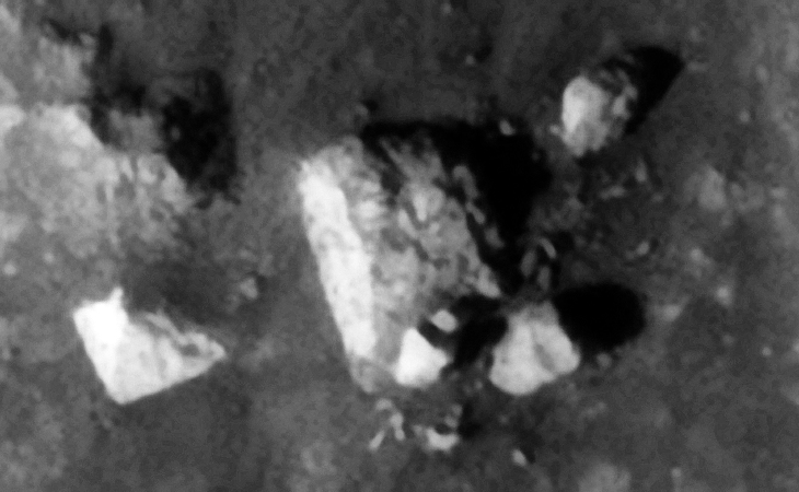 Destroyed machine or structure, the top right object has circular features and what looks like a short pipe sticking out