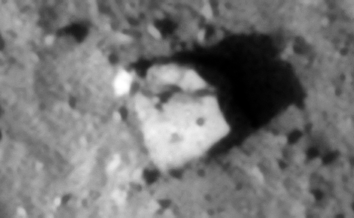 Metallic wreckage? Note the three similar sized dome-like features on the surface