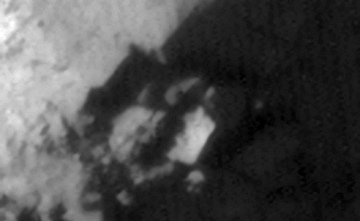 Embedded megalithic block within machined/artificial surface feature