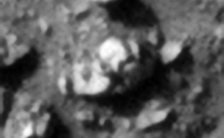 Smashed craft with two circular sides, small doughnut ring in the center and a rectangular, bent piece on top to the right