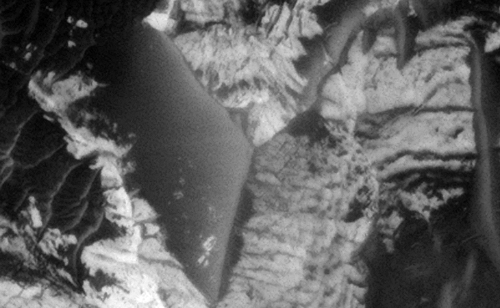 Smooth, flat triangular feature, one side of a pyramid under construction? the two shorter sides each measure approximately 30 metres in length (PSP_006754_1790)