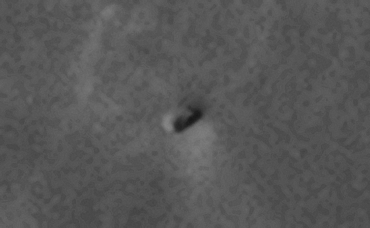 Semi-circular craft with small dome at the apex with possible impact mark on the surface towards the bottom right of the craft?