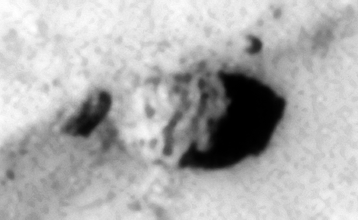 Partially buried smashed machine-like object with smaller features or parts on top