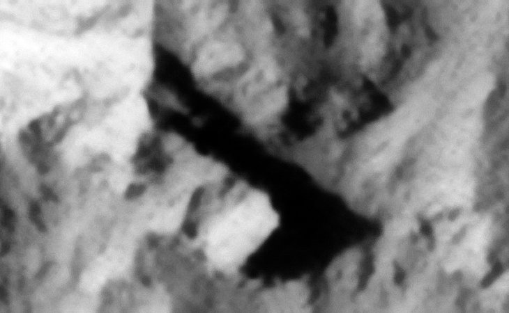 Underground entrance-way or metal plate, a small rectangular object with several slots is located towards the right