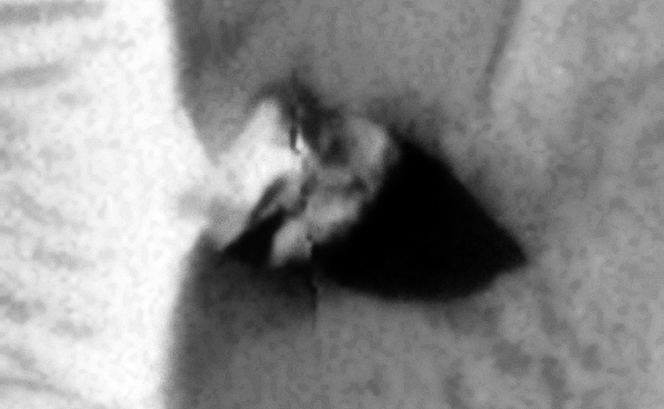 Circular disc with triangular object on top, looks like an 'alien' head with two eyes