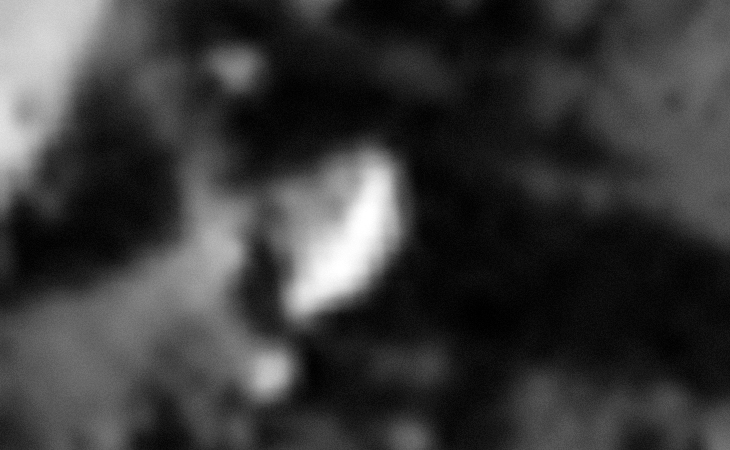 A disc-shaped object half-buried in the side of a small hill