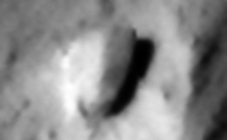 A half-buried rectangular object with rounded edge above the surface