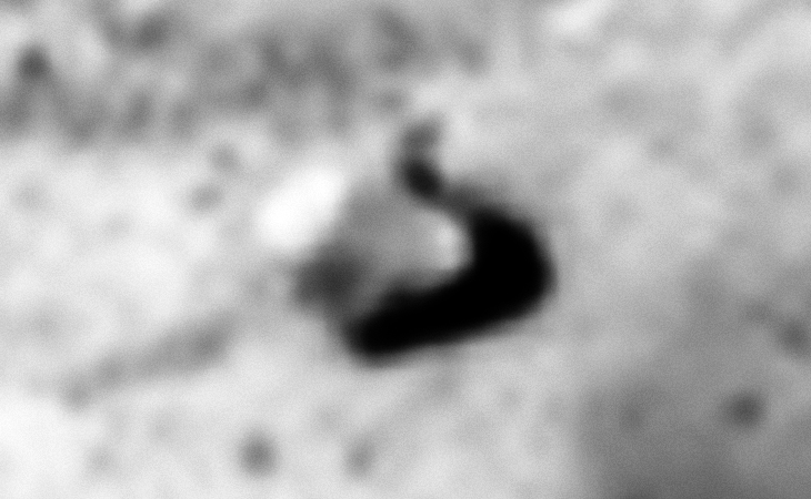 A strange triangular-shaped object with rounded corners and a larger dome-like feature on top